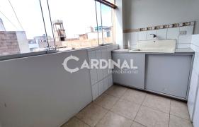 Área de lavandería con mueble y lavadero con amplias ventanas con vista interna